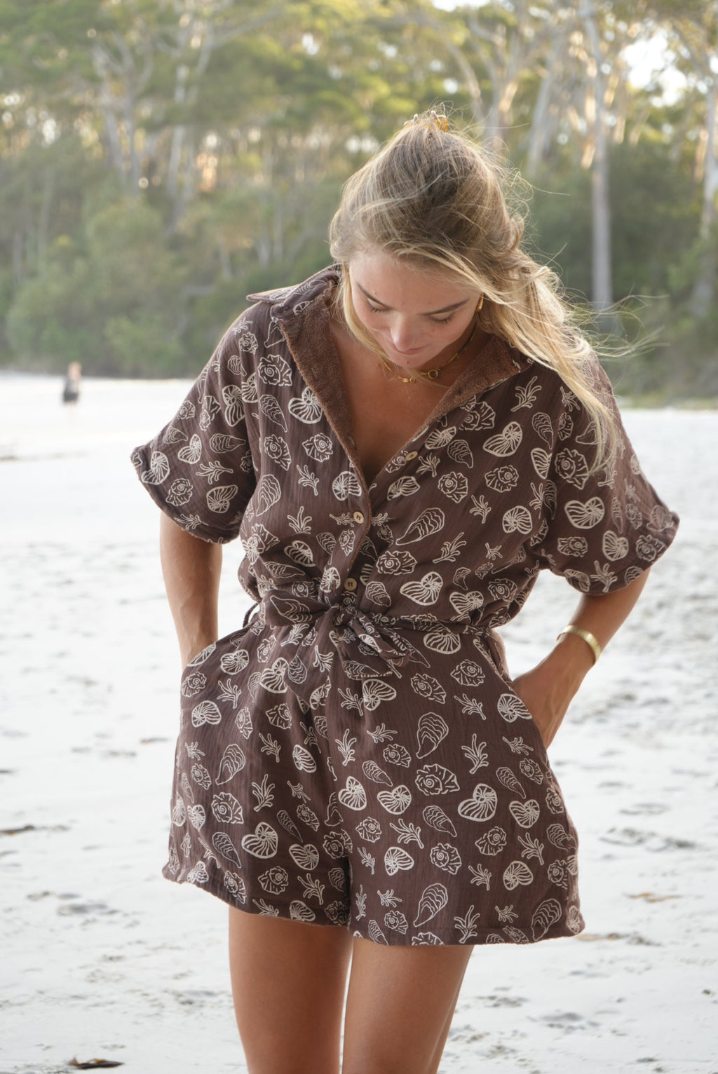 Woman wearing brown patterned towel-wear. This wearable towel is made from Organic Cotton and a towel outfit.