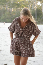 Woman wearing brown patterned towel-wear. This wearable towel is made from Organic Cotton and a towel outfit.
