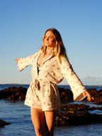 Woman wearing brown patterned towel-wear. This wearable towel is made from Organic Cotton and a towel outfit.